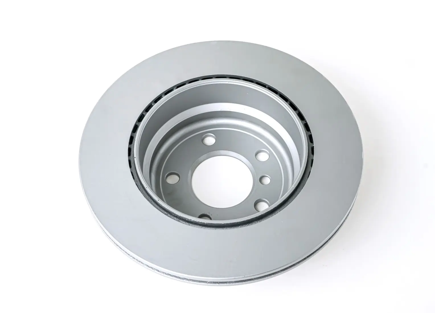 Silver brake disk with multiple holes and a ventilated design, top view, shown on a white background, featuring a smooth and polished surface.
