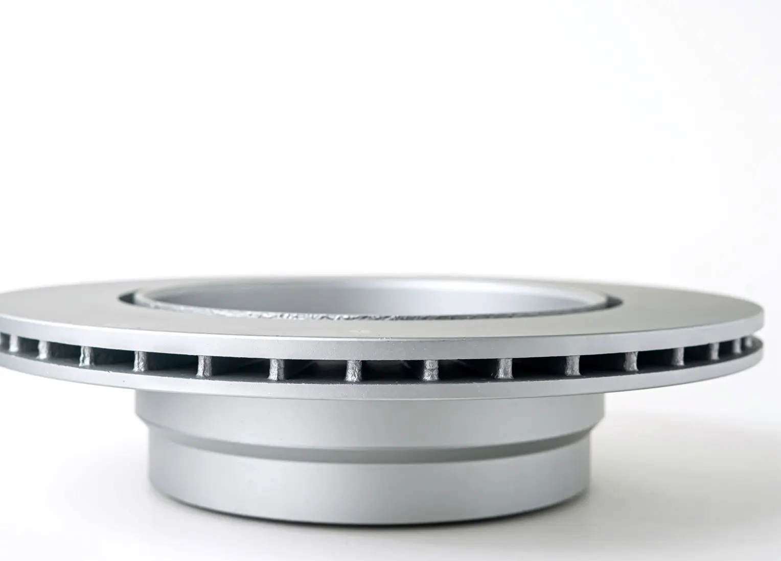 Silver brake disk with a ventilated design, side view, showing the internal cooling vents and smooth polished surface.