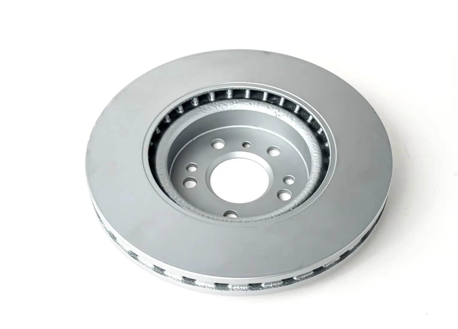 A vented brake disc viewed from the top, showing the central hub with bolt holes and the cooling vents around the outer edge.