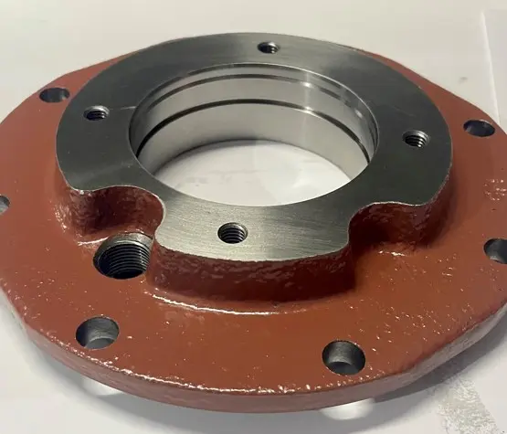 A metal cover component with a textured red base and multiple bolt holes, displayed on a white background.