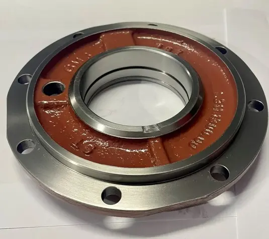 A metal cover component with a red base, multiple bolt holes, and a central circular opening, displayed on a white background.