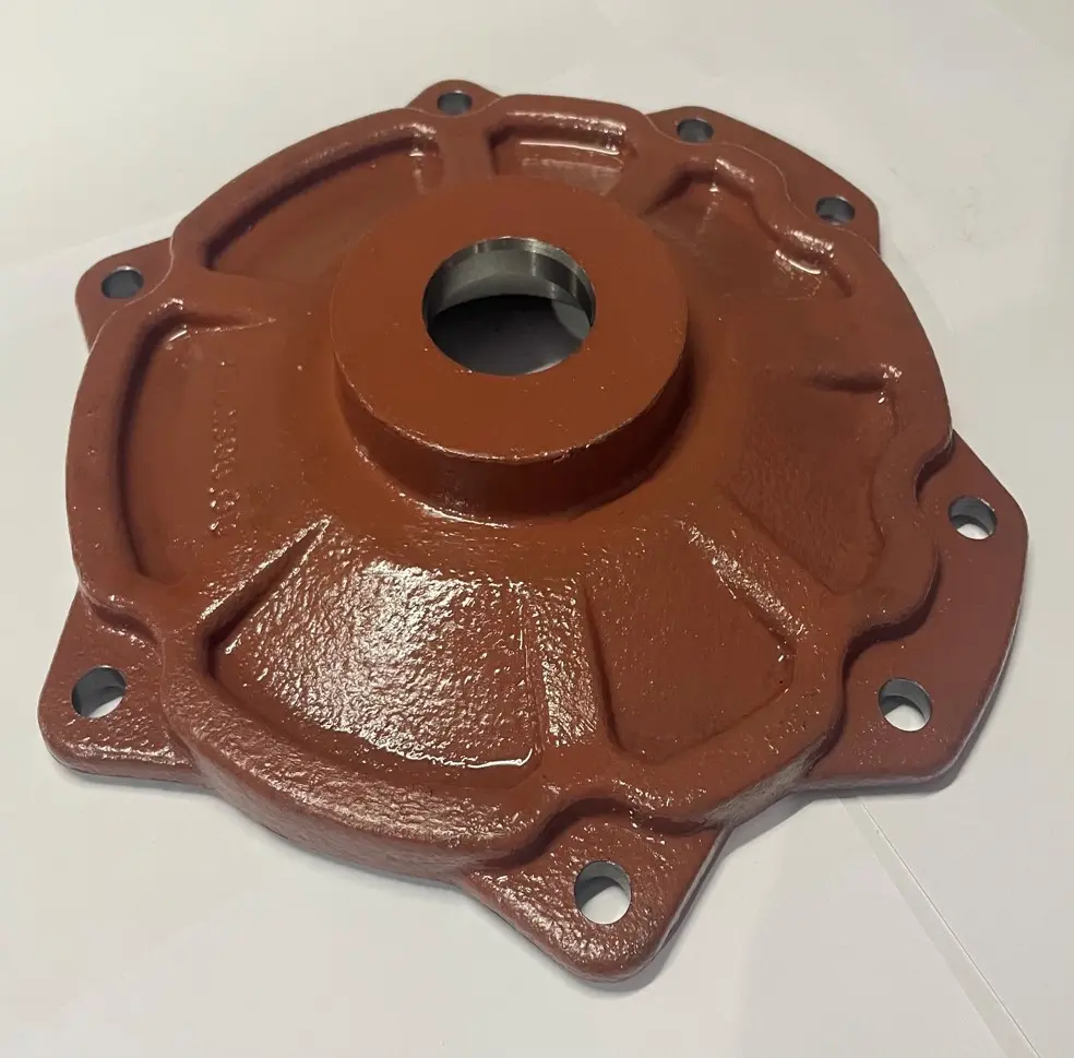 A metal cover component with a red textured finish, multiple bolt holes, and a central circular opening, displayed on a white background.