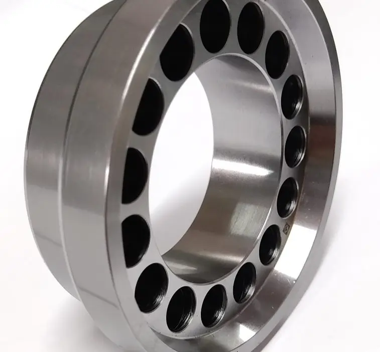 A metal piston component with multiple circular openings around its circumference, displayed on a white background, angled view.