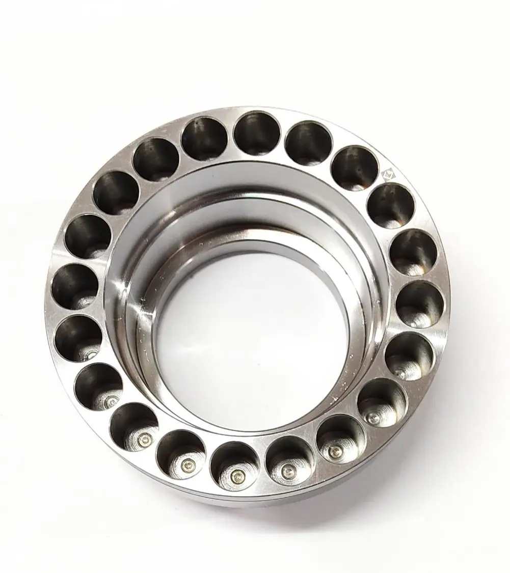 A metal piston component with multiple circular openings around its circumference, displayed on a white background, top view.
