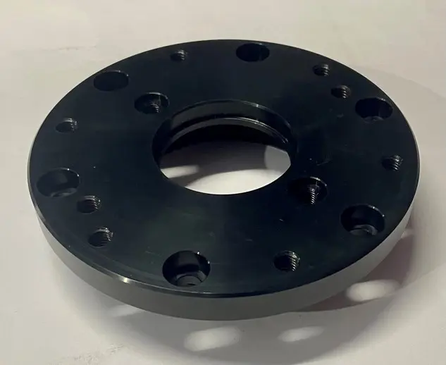 A black metal LTD seal component with multiple bolt holes and a central circular opening, displayed on a white background.