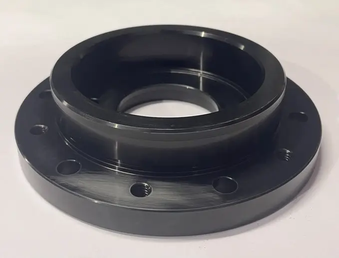 A black metal LTD seal component with a raised cylindrical section, multiple bolt holes, and a central circular opening, displayed on a white background.