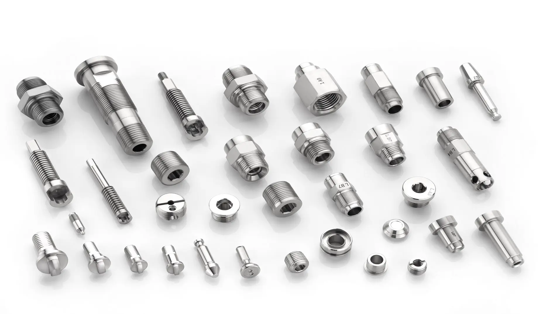 Various metal valve manifold components arranged on a white surface.
